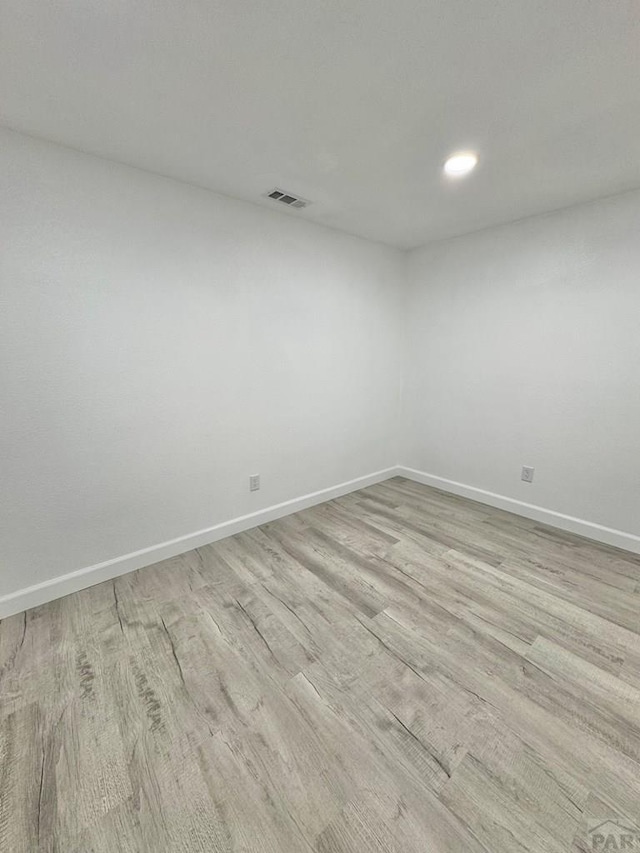 spare room featuring recessed lighting, visible vents, baseboards, and wood finished floors