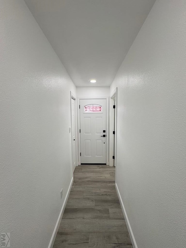 corridor with wood finished floors and baseboards