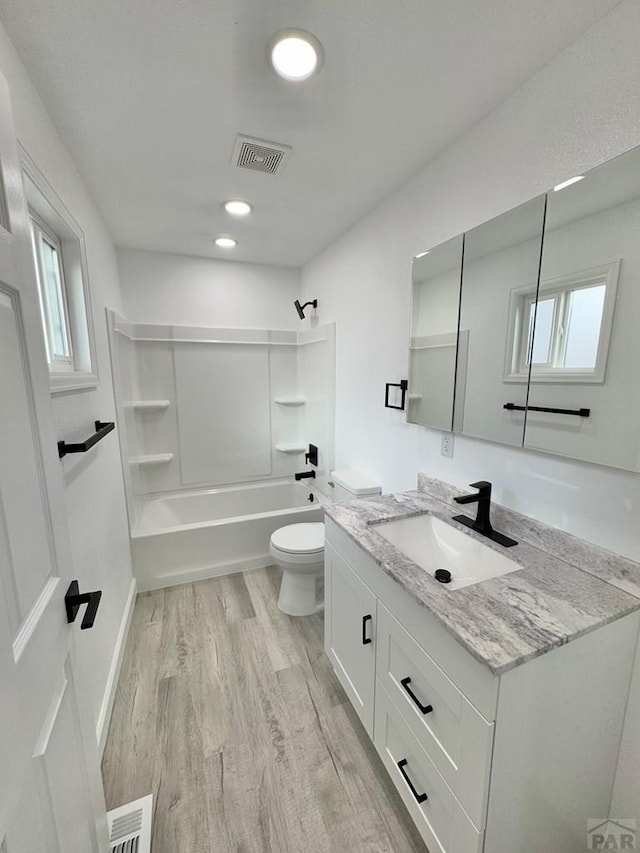 bathroom featuring toilet, visible vents, wood finished floors, and shower / bathtub combination