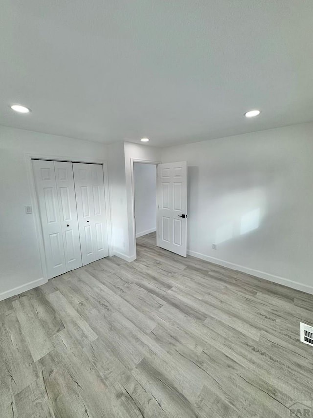 unfurnished bedroom featuring light wood-style floors, recessed lighting, and baseboards