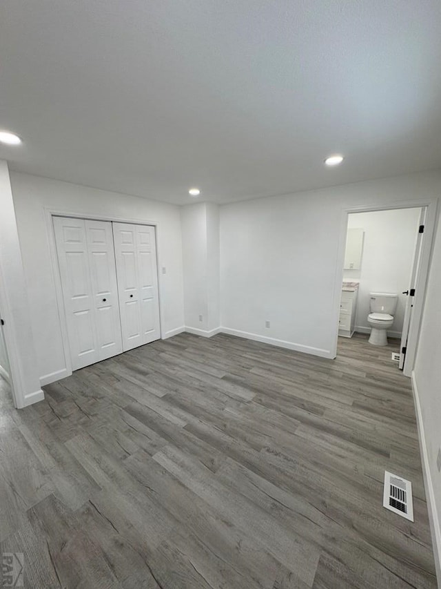 unfurnished bedroom with baseboards, visible vents, wood finished floors, and recessed lighting