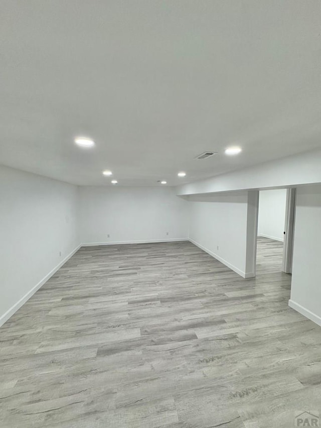 finished basement with recessed lighting, visible vents, light wood-style flooring, and baseboards