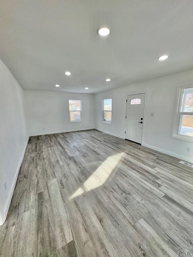 entryway featuring baseboards, plenty of natural light, visible vents, and wood finished floors