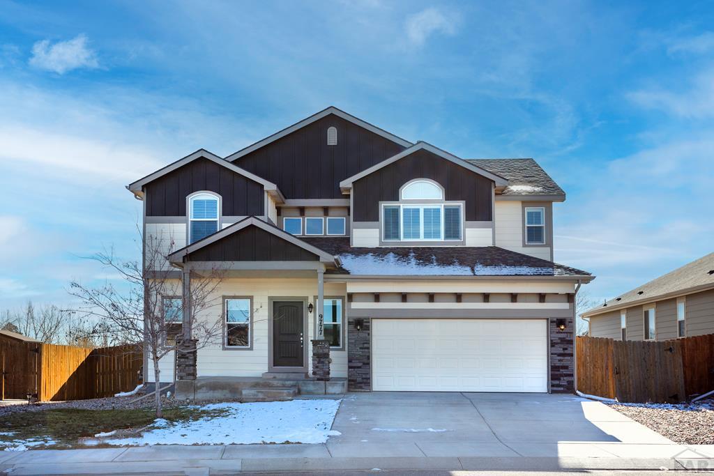 craftsman inspired home featuring driveway, a garage, fence, and board and batten siding