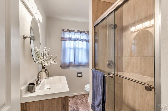 bathroom with toilet, a stall shower, and vanity