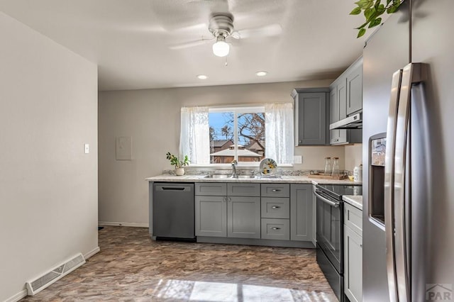 kitchen featuring visible vents, a sink, gray cabinetry, stainless steel appliances, and under cabinet range hood