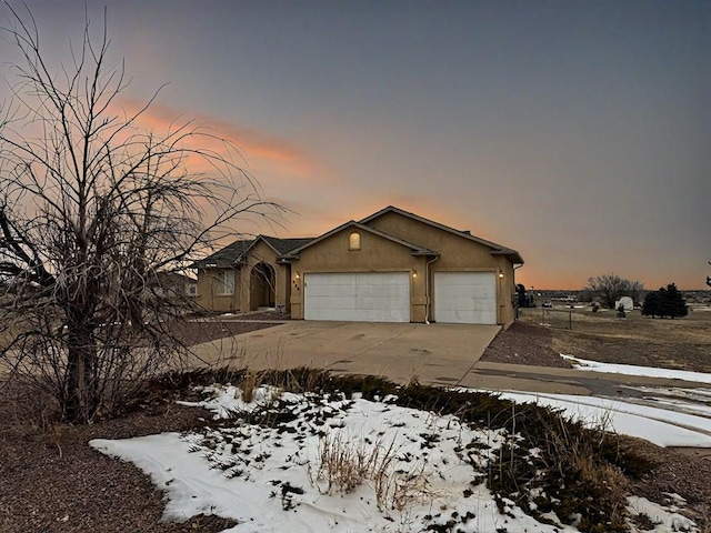 view of front of house featuring a garage, driveway, and stucco siding