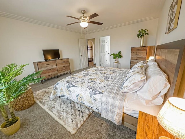 bedroom with carpet floors, arched walkways, crown molding, and ceiling fan