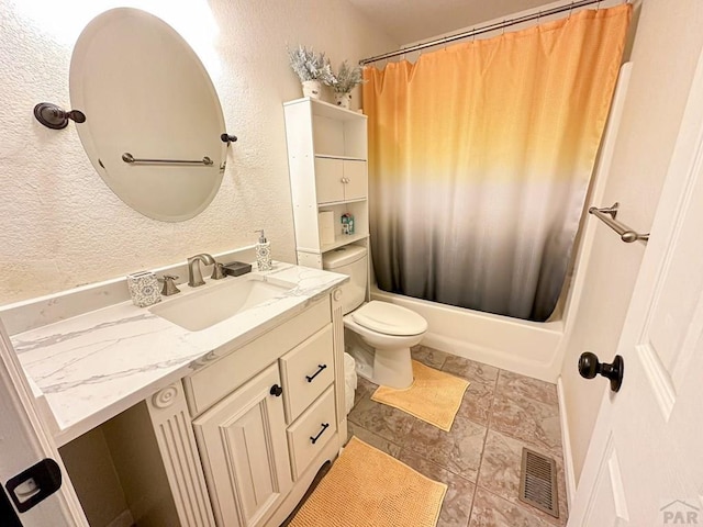 full bathroom with visible vents, a textured wall, toilet, shower / bath combo with shower curtain, and vanity