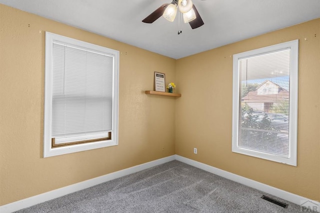 unfurnished room with carpet, visible vents, ceiling fan, and baseboards