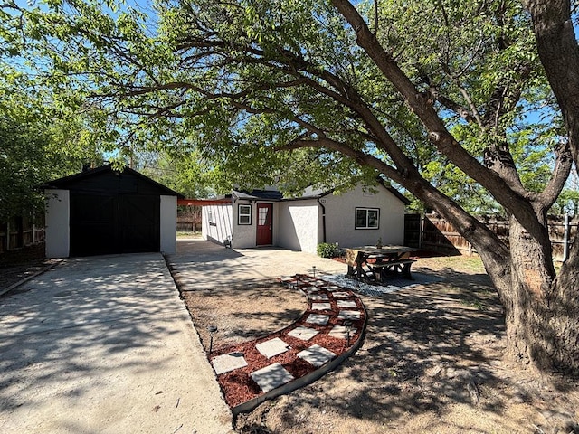 521 Tyler St, Pueblo, CO 81004 - view of front of property featuring an outbuilding, fence, concrete driveway, and stucco siding