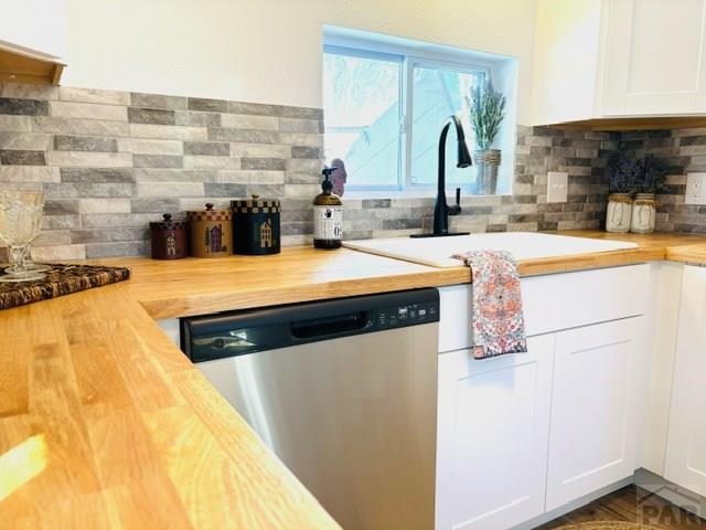 521 Tyler St, Pueblo, CO 81004 - kitchen with dishwasher, wood counters, a sink, tasteful backsplash, and white cabinets