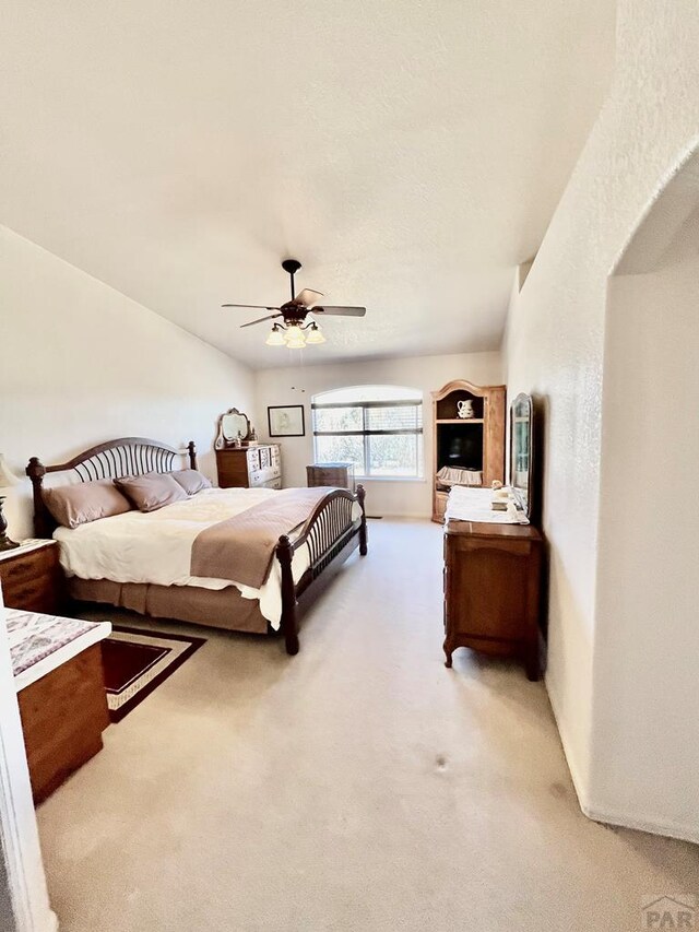 bedroom featuring light carpet and a ceiling fan