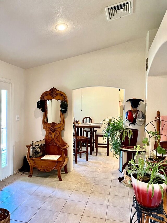 sitting room with a textured ceiling, light tile patterned flooring, and visible vents