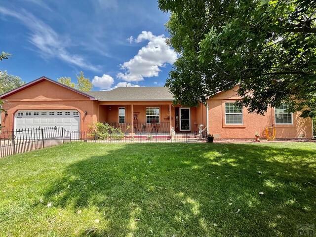 single story home with a garage, a front yard, fence, and stucco siding