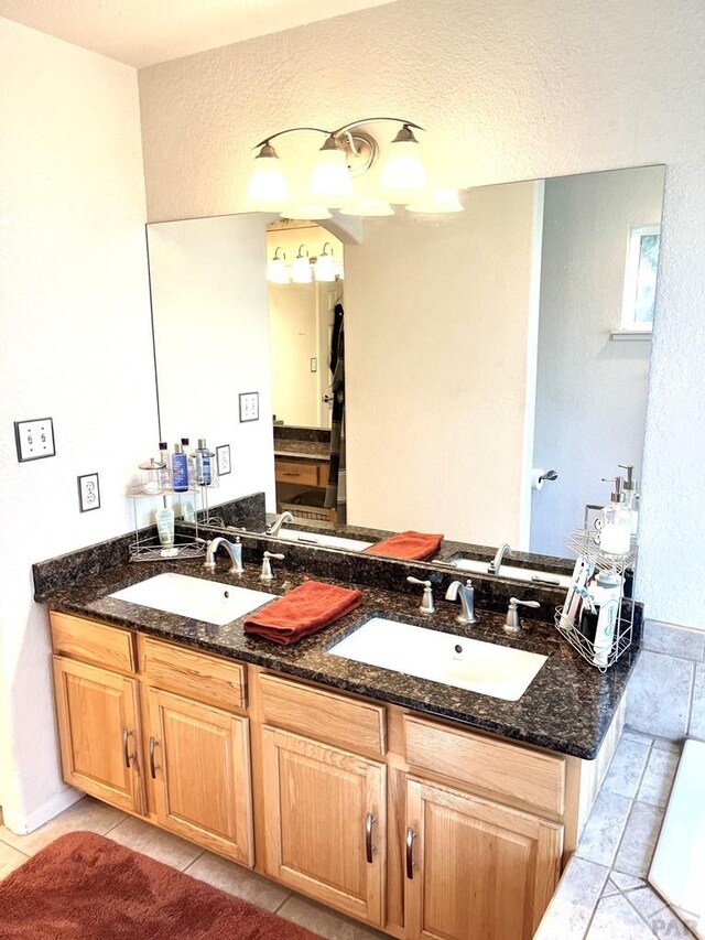 bathroom with double vanity, a sink, and tile patterned floors