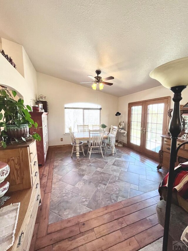 dining space with ceiling fan, french doors, a textured ceiling, and a wealth of natural light