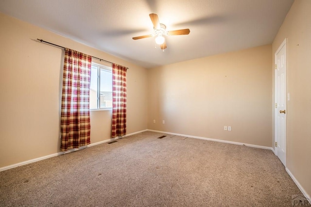 spare room featuring carpet floors, ceiling fan, and baseboards