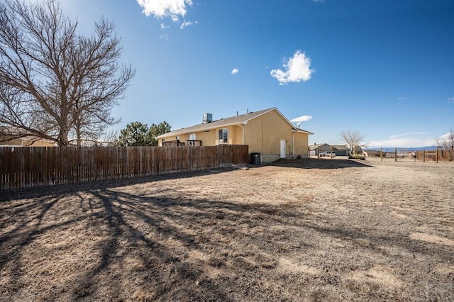 view of side of home featuring fence