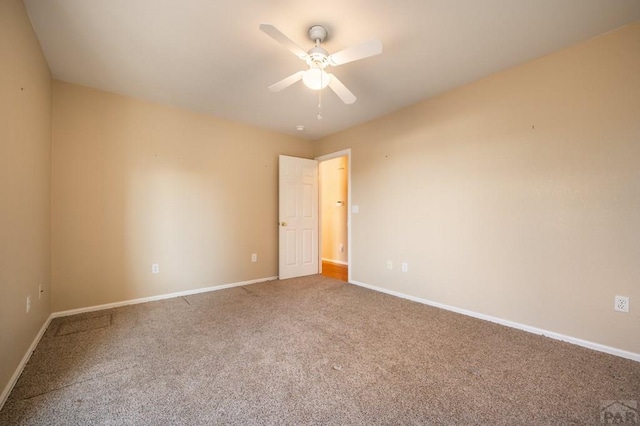 spare room featuring baseboards, a ceiling fan, and carpet flooring