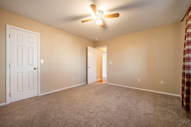 spare room with ceiling fan, carpet floors, and baseboards