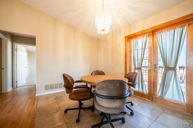 dining space featuring french doors, visible vents, an inviting chandelier, tile patterned flooring, and baseboards