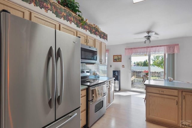 kitchen featuring appliances with stainless steel finishes, light wood-type flooring, ceiling fan, decorative backsplash, and light brown cabinetry