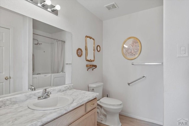 bathroom with a shower with shower curtain, vanity, toilet, visible vents, and wood finished floors