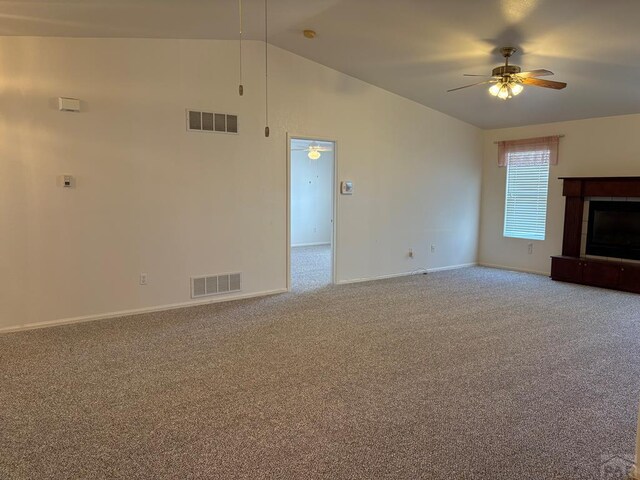 unfurnished living room featuring carpet, ceiling fan, vaulted ceiling, and visible vents