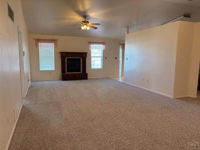 unfurnished living room featuring ceiling fan, baseboards, carpet flooring, and visible vents