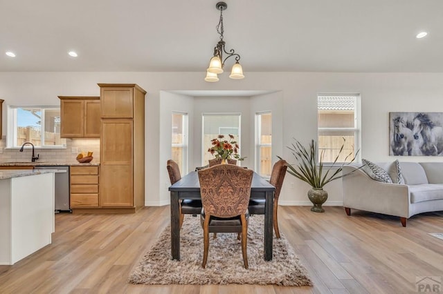 dining space featuring light wood-type flooring, a healthy amount of sunlight, and baseboards