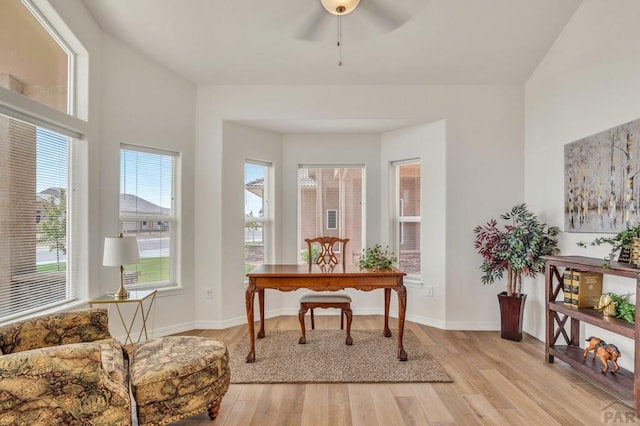 office area with a ceiling fan, baseboards, and light wood finished floors