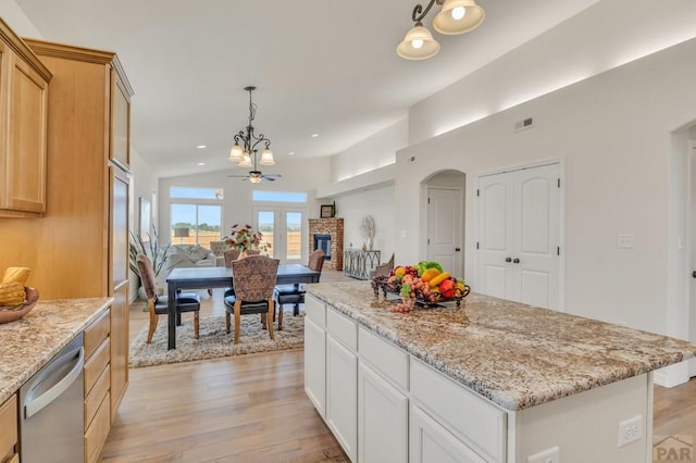 kitchen with dishwasher, open floor plan, decorative light fixtures, a center island, and white cabinetry