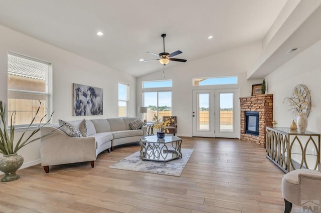 living area featuring a fireplace, light wood finished floors, lofted ceiling, recessed lighting, and baseboards