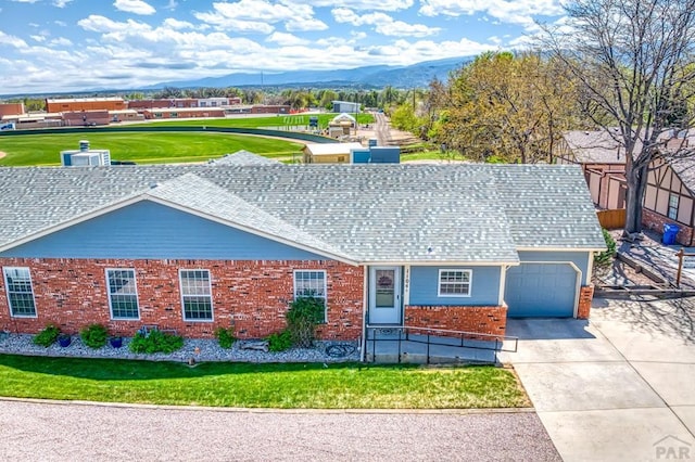 1104 Fairview Ave Unit A, Canon City, CO 81212 - ranch-style house featuring a mountain view, a garage, driveway, brick siding, and a front yard