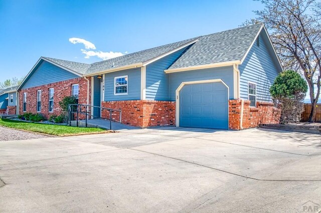 1104 Fairview Ave Unit A, Canon City, CO 81212 - single story home with brick siding, a garage, concrete driveway, and roof with shingles