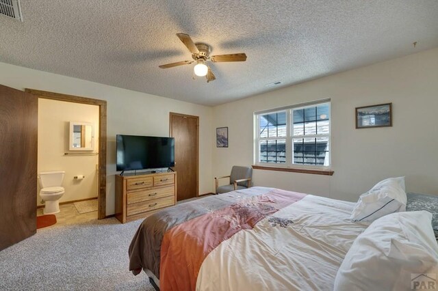 1104 Fairview Ave Unit A, Canon City, CO 81212 - bedroom featuring a textured ceiling, ensuite bath, light colored carpet, and a ceiling fan