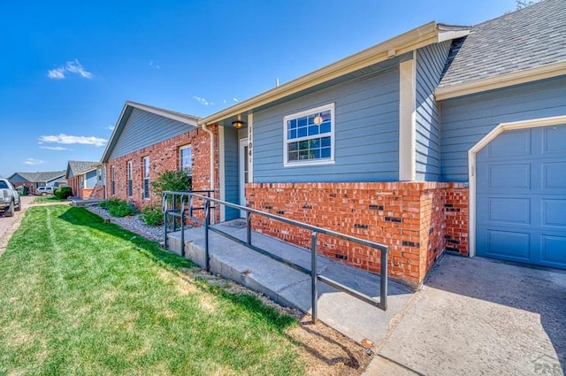 1104 Fairview Ave Unit A, Canon City, CO 81212 - view of side of property with brick siding, a lawn, an attached garage, and concrete driveway