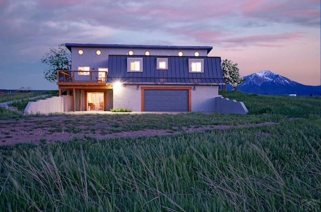 view of front of property with a deck with mountain view, metal roof, a standing seam roof, and stucco siding