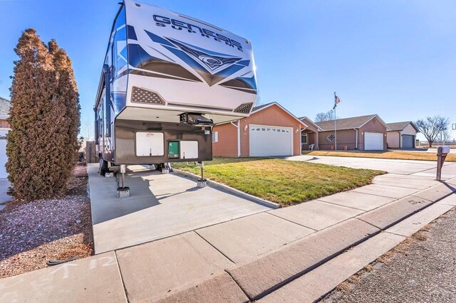 view of front of home with driveway, a garage, and a front yard