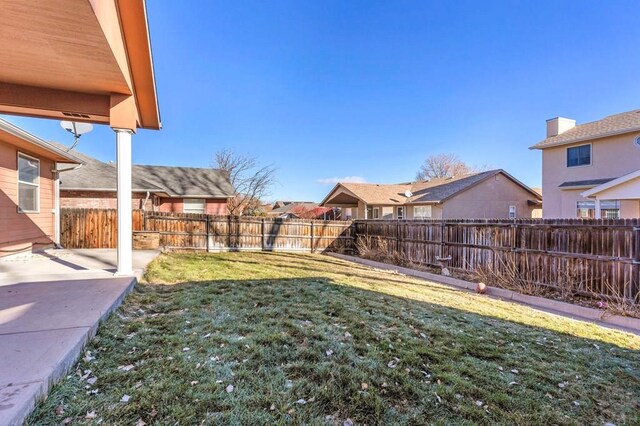 view of yard with a patio area, a fenced backyard, and a residential view