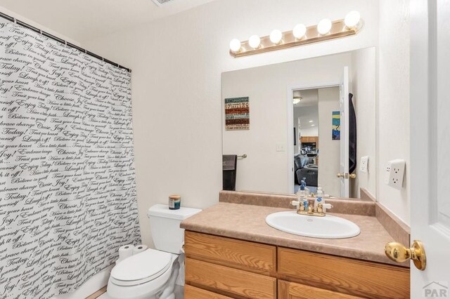 full bath with toilet, curtained shower, and vanity