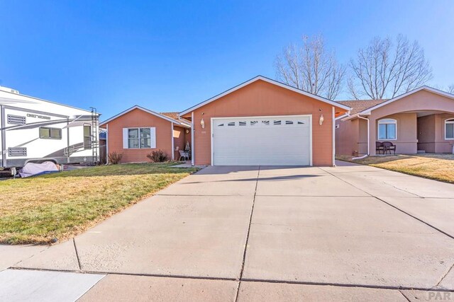 ranch-style house featuring concrete driveway, a front lawn, and an attached garage