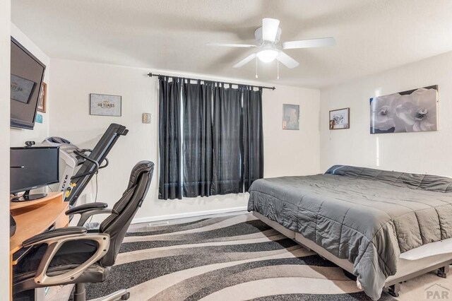 bedroom with ceiling fan and baseboards