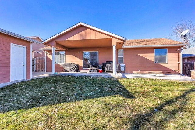 back of house with a patio area, fence, and a lawn