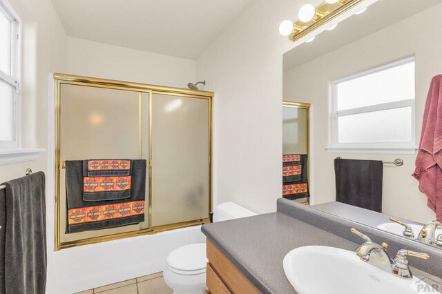 full bath featuring enclosed tub / shower combo, vanity, toilet, and tile patterned floors