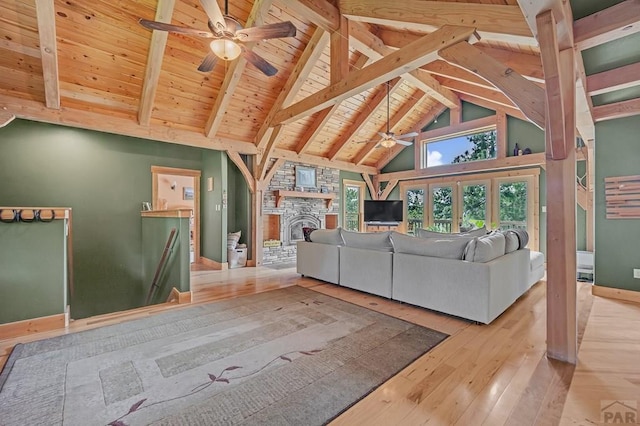 8564 Ridge Rd, Beulah, CO 81023 - living area with ceiling fan, hardwood / wood-style floors, a wooden ceiling with exposed beams, high vaulted ceiling, and a stone fireplace