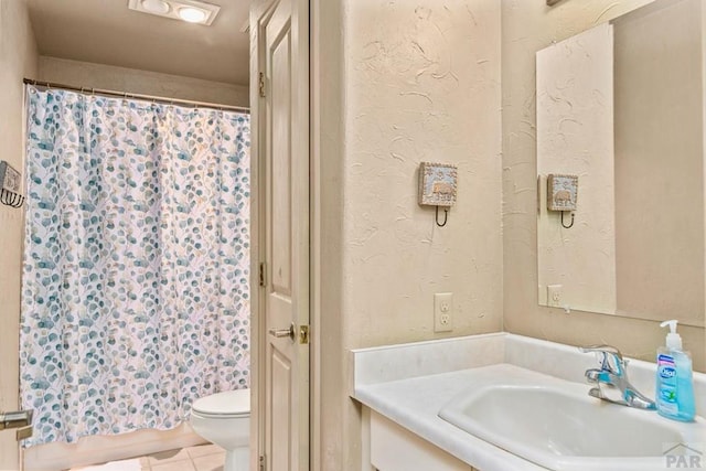 full bath featuring a textured wall, tile patterned flooring, toilet, a shower with shower curtain, and vanity