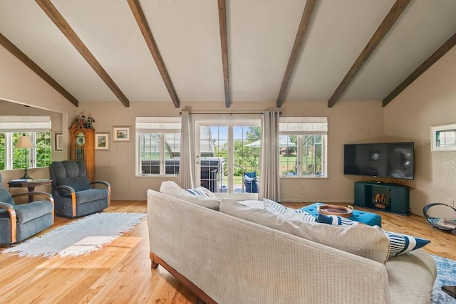 living room featuring lofted ceiling with beams, baseboards, and wood finished floors