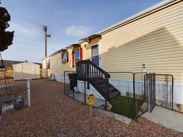 view of side of home with an outdoor structure, fence, and a shed